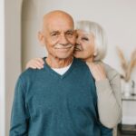 A joyful elderly couple embracing each other in a cozy indoor setting, exuding love and happiness.